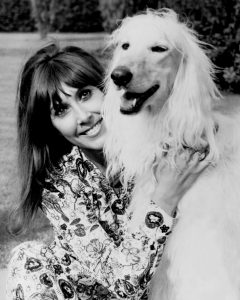 B/W Image of Anita Harris cuddling a dog.